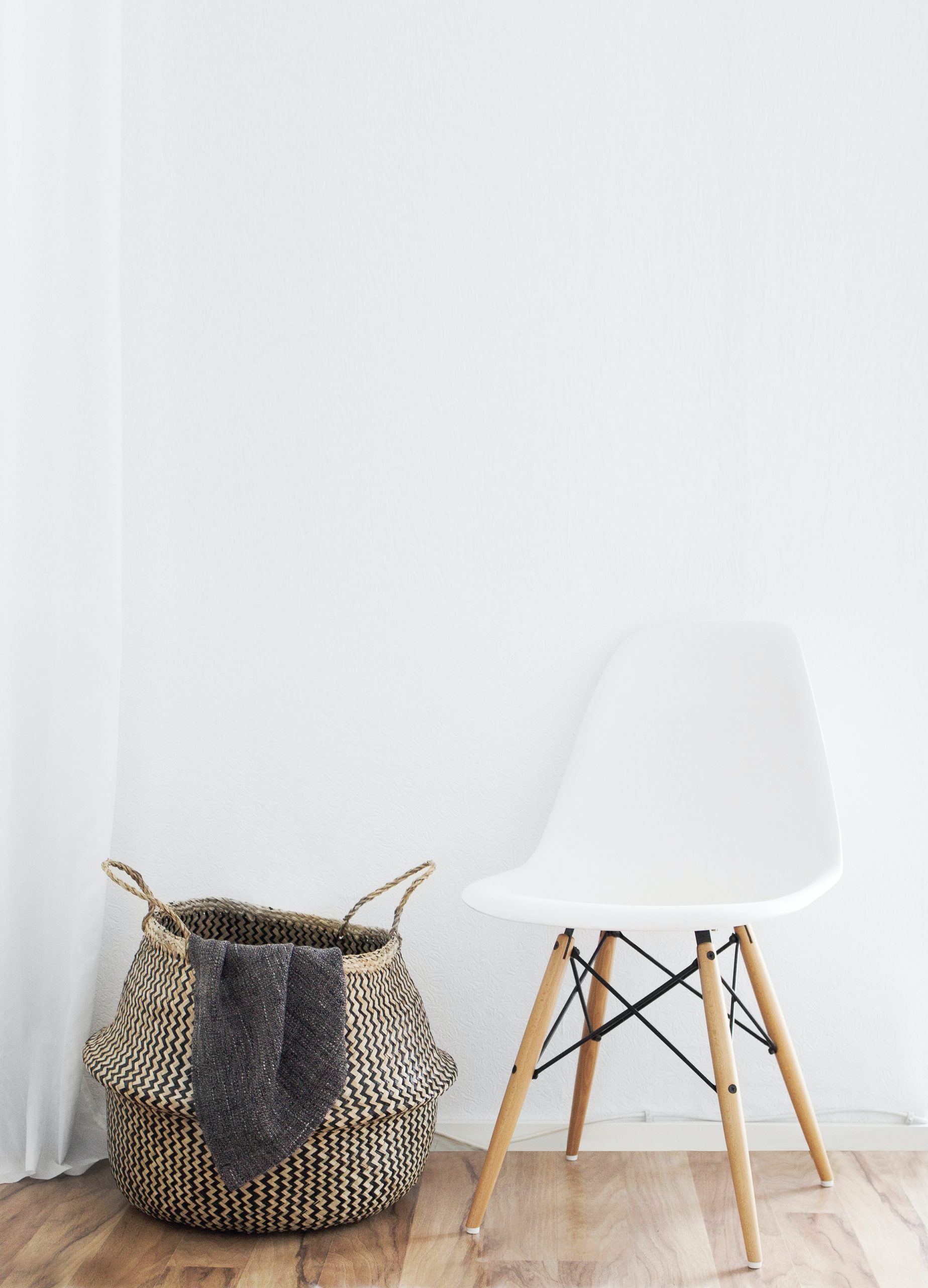 Photo by Sarah Dorweiler white and brown chairs beside wicker basket near white wall